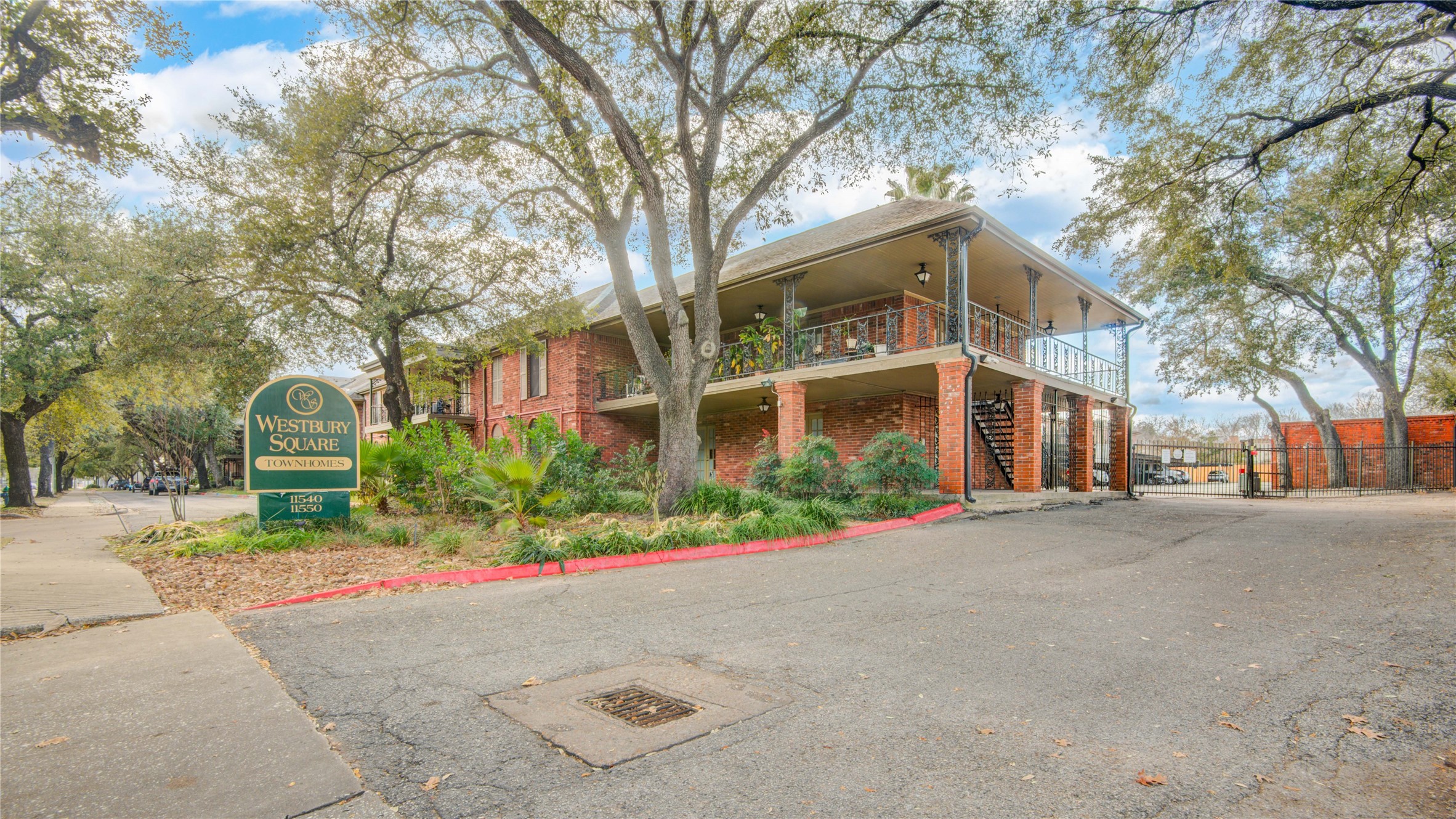 11540 Chimney Rock Road, Unit 117 Houston, TX 77035 - Photo 2 of 38 a front view of a building with a yard and trees