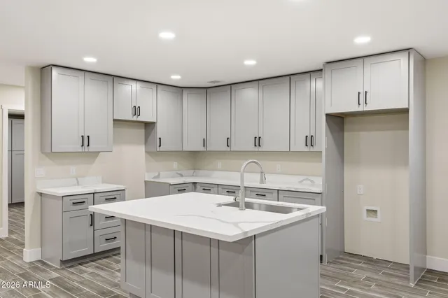 a kitchen with a sink a stove a refrigerator and white cabinets