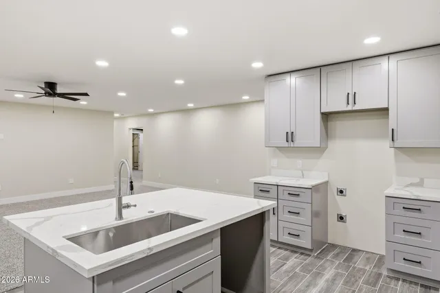 a kitchen with a white cabinets and wooden floor