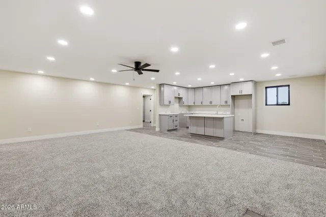 an empty room with a ceiling fan and a window