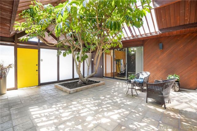 a view of a patio with table and chairs and potted plants