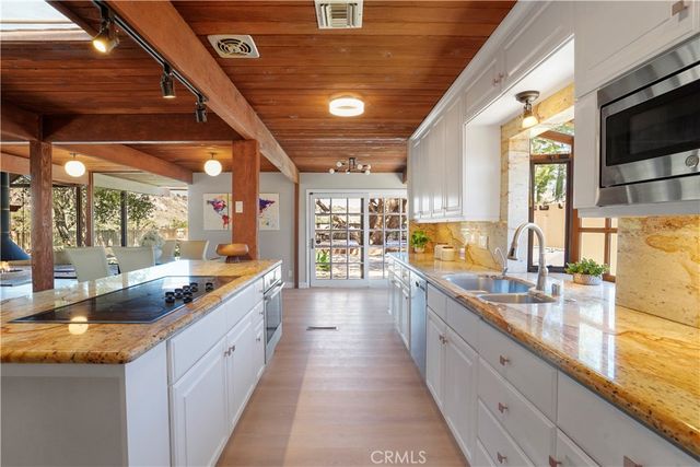 a large kitchen with stainless steel appliances granite countertop a sink and dishwasher with a large window