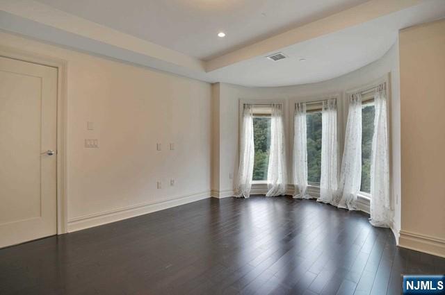 55 Eton Row Weehawken, NJ 07086 - Photo 11 of 28 an empty room with wooden floor and windows