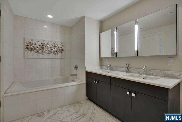 55 Eton Row Weehawken, NJ 07086 - Photo 12 of 28 a bathroom with a double vanity sink mirror and bathtub