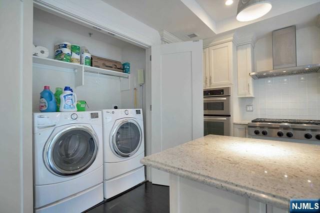 55 Eton Row Weehawken, NJ 07086 - Photo 15 of 28 a kitchen with a stove top oven and cabinets