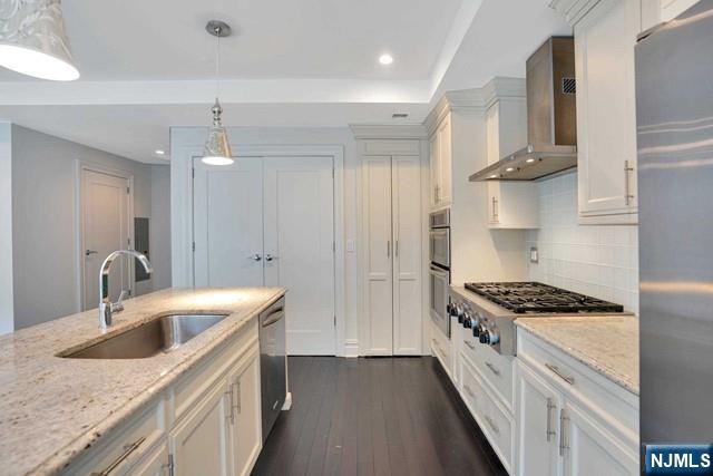 55 Eton Row Weehawken, NJ 07086 - Photo 5 of 28 a kitchen with stainless steel appliances granite countertop a sink stove and cabinets