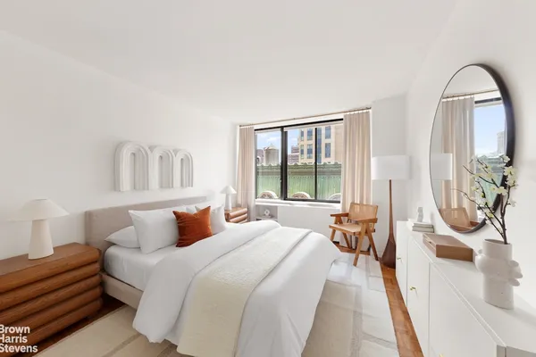 a bedroom with furniture and a large window