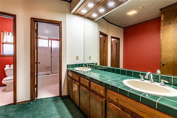 a bathroom with a granite countertop sink a mirror and a bathtub