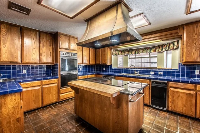 a kitchen with stainless steel appliances granite countertop a sink and a counter space