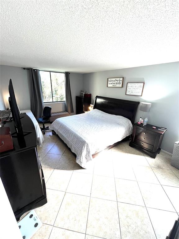 737 Southeast 1st Way, Unit 302 Deerfield Beach, FL 33441 - Photo 11 of 21 a bedroom with a bed and wooden floor