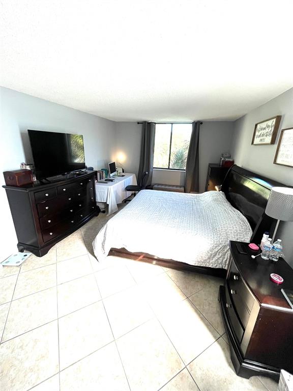 737 Southeast 1st Way, Unit 302 Deerfield Beach, FL 33441 - Photo 12 of 21 a bedroom with a bed and a flat screen tv