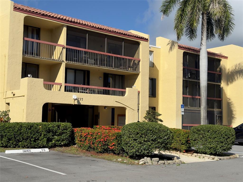 737 Southeast 1st Way, Unit 302 Deerfield Beach, FL 33441 - Photo 2 of 21 a front view of a house with a yard