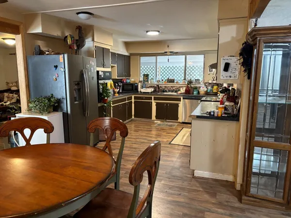 a kitchen with stainless steel appliances dining table chairs and wooden floor