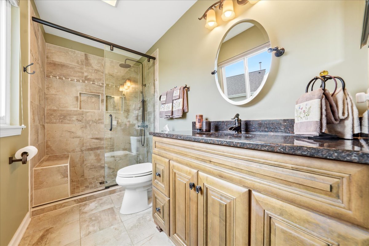 334 Clearview Circle Round Lake, IL 60073 - Photo 16 of 36 a bathroom with a granite countertop sink a toilet and a mirror