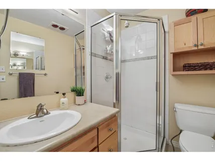 a bathroom with a granite countertop sink toilet and shower