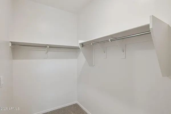 a view of walk in closet with empty racks