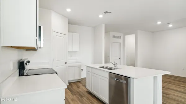 a kitchen with stainless steel appliances a stove a microwave a sink and cabinets