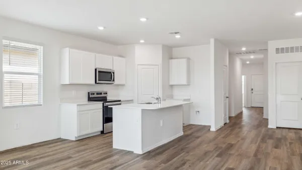 a kitchen with granite countertop a stove a sink and a microwave