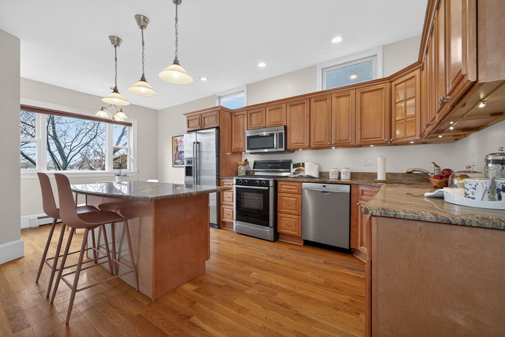 60 Iffley Road, Unit 2 Boston, MA 02130 - Photo 9 of 26 a kitchen with granite countertop wooden floors stainless steel appliances and a window