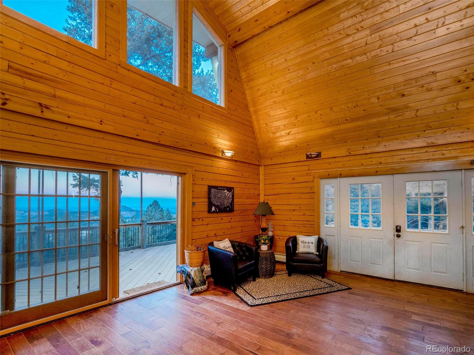 25633 Independence Trail Evergreen, CO 80439 - Photo 12 of 39 a view of a patio with table and chairs with wooden floor and fence