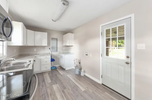 a kitchen with a white stove top oven sink and cabinets
