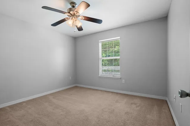 a bedroom with a large bed and a chandelier fan