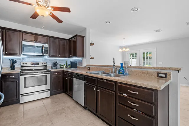 a kitchen with stainless steel appliances granite countertop a refrigerator stove a sink and dishwasher