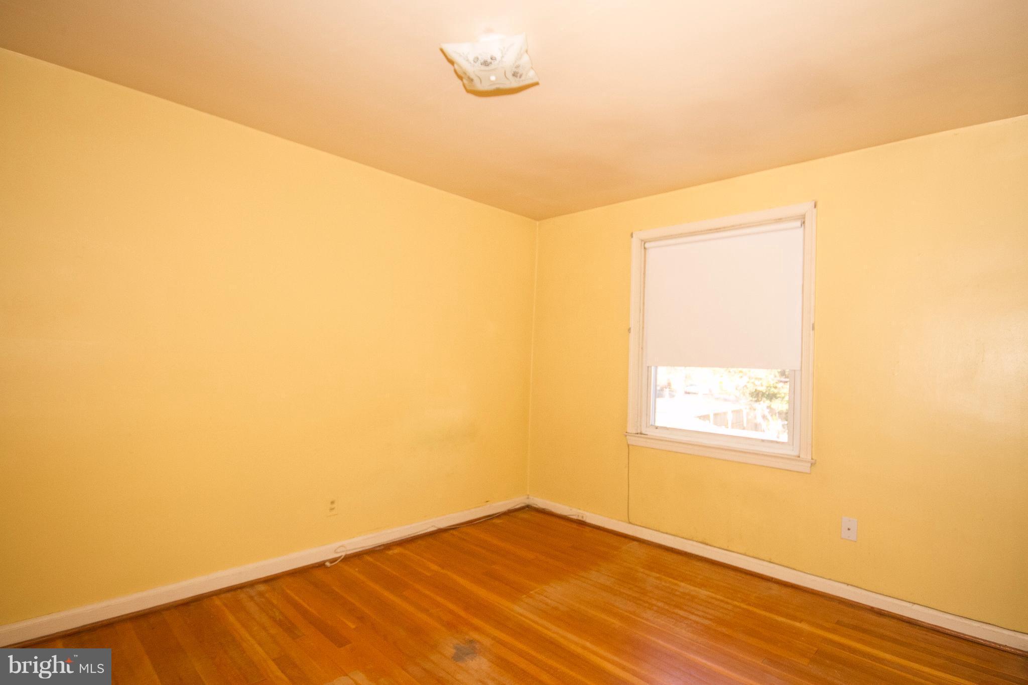 136 Garden Ridge Road Baltimore, MD 21228 - Photo 13 of 25 a view of an empty room with wooden floor and a window