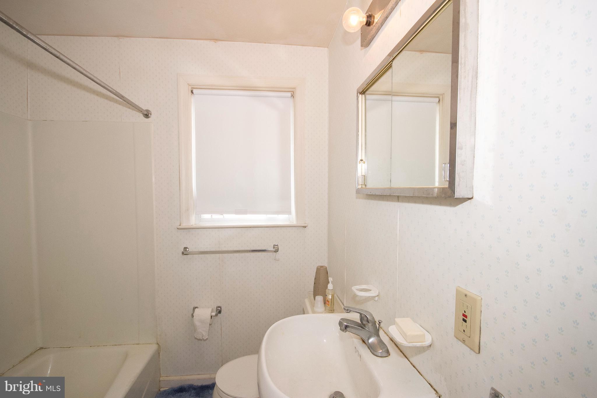 136 Garden Ridge Road Baltimore, MD 21228 - Photo 17 of 25 a bathroom with a sink a toilet and mirror