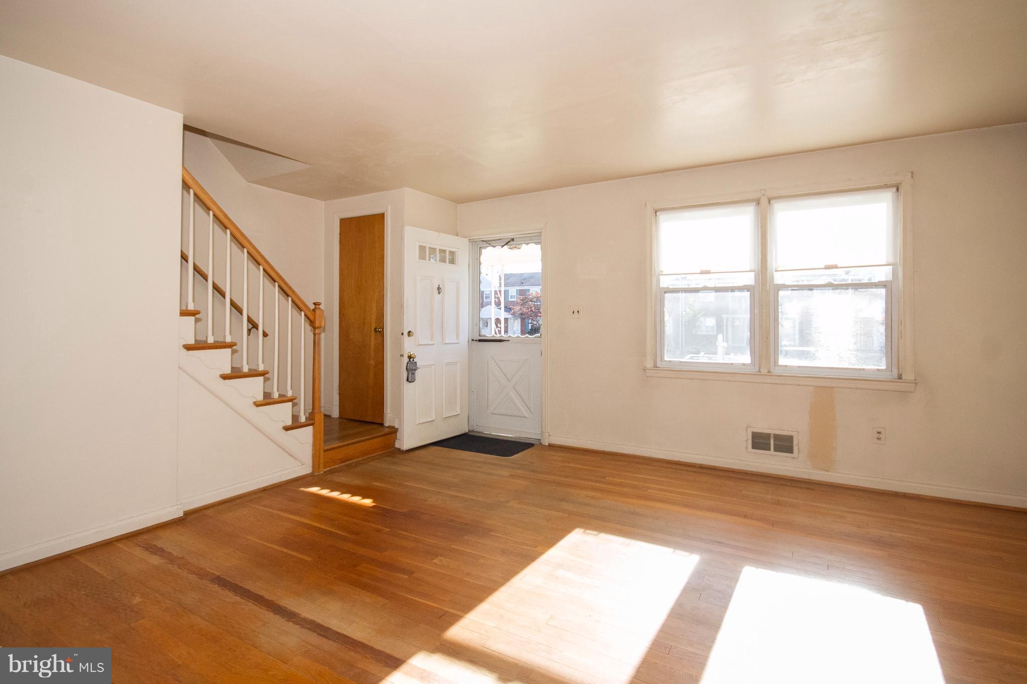 136 Garden Ridge Road Baltimore, MD 21228 - Photo 3 of 25 a view of an empty room with wooden floor and windows