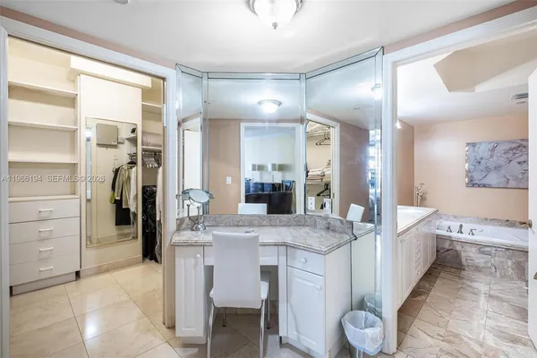 a bathroom with a granite countertop sink a large mirror and a bathtub