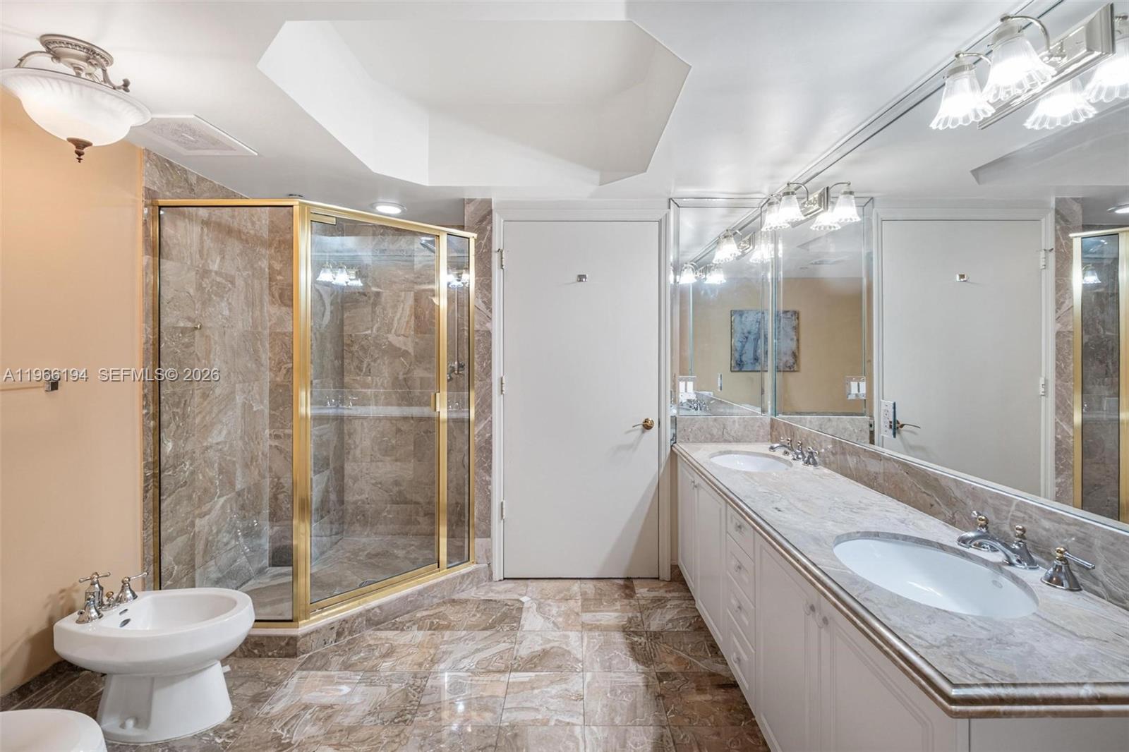9595 Collins Avenue, Unit N6J Surfside, FL 33154 - Photo 25 of 37 a bathroom with a granite countertop sink a toilet a mirror and shower