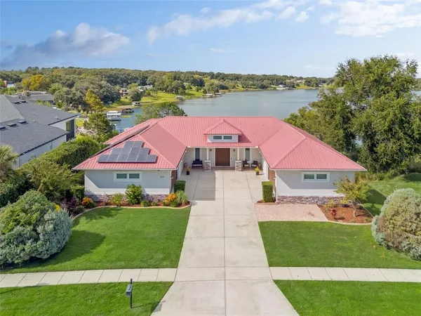 a front view of a house with a yard and lake view