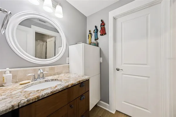 a bathroom with a granite countertop sink and a mirror