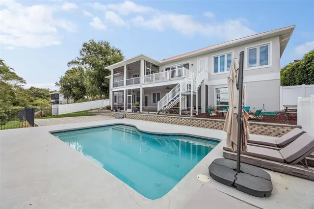 a view of a house with pool and chairs