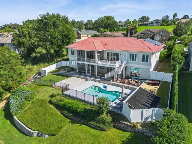 a aerial view of a house with outdoor space and lake view