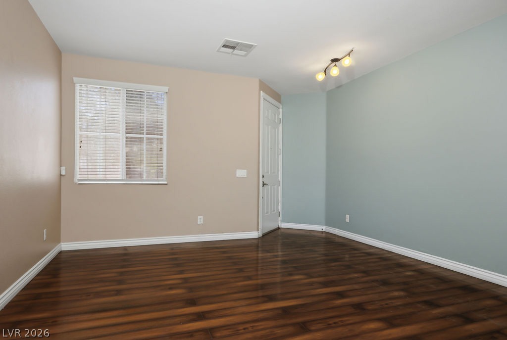 9712 North Running Rabbit Street Las Vegas, NV 89143 - Photo 5 of 42 Rich wood flooring grounds this versatile room, bathed in natural light from a well-sized window.