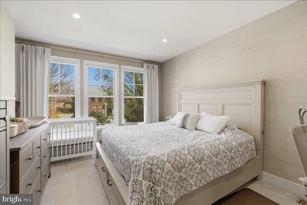 a bedroom with a bed and a large window