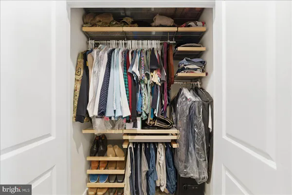 a view of walk in closet with clothes and shoes