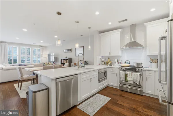 a kitchen with stainless steel appliances granite countertop a stove and white cabinets