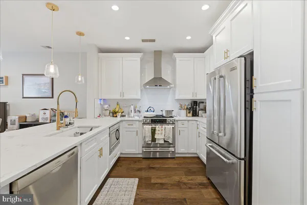 a kitchen with a sink stainless steel appliances and white cabinets