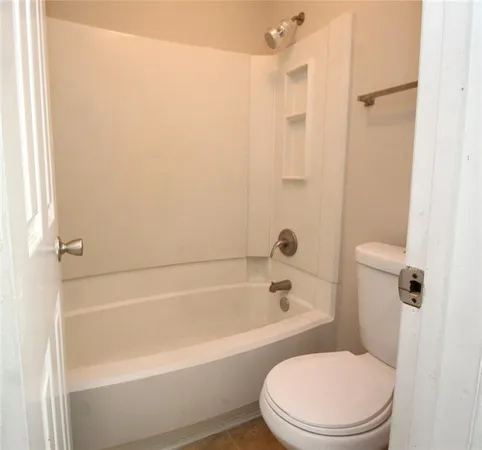 a white toilet sitting next to a bath tub