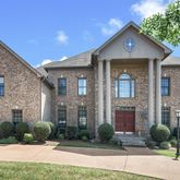 a front view of a house with garden and plants