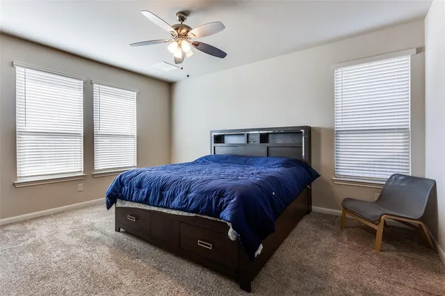 a spacious bedroom with a bed and chair