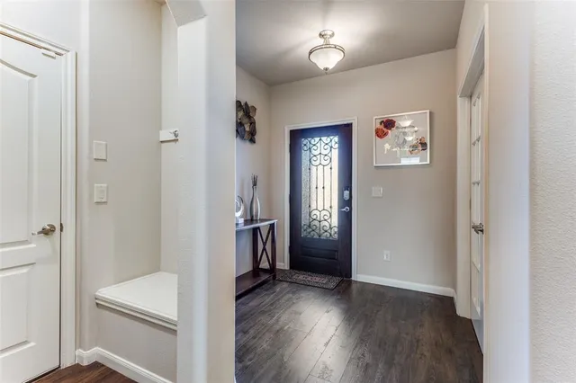 a view of a hallway with wooden floor and a bathroom
