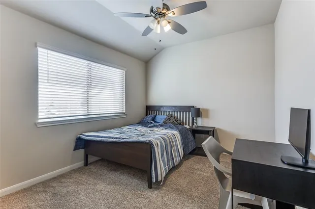 a bedroom with a bed desk and a window