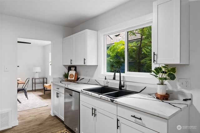 a kitchen with sink a window and cabinets