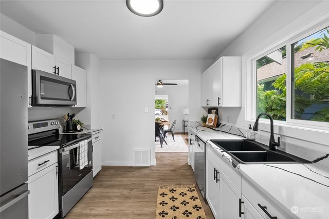 a kitchen with stainless steel appliances a sink a stove and a refrigerator