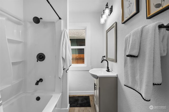 a bathroom with a sink a mirror a shower and a bathtub