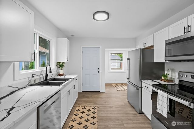 a kitchen with stainless steel appliances a sink stove and refrigerator